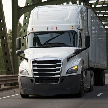 white semi-truck crossing bridge in route from Michigan to New York