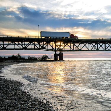 Freight Shipping from New York to Florida - Truck on bridge against horizon