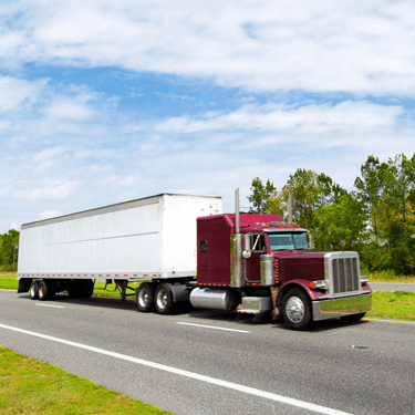 Freight Shipping from Ohio to Florida - Red freight truck in left lane of two lane highway