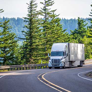 white semi-truck driving Michigan two lane highway