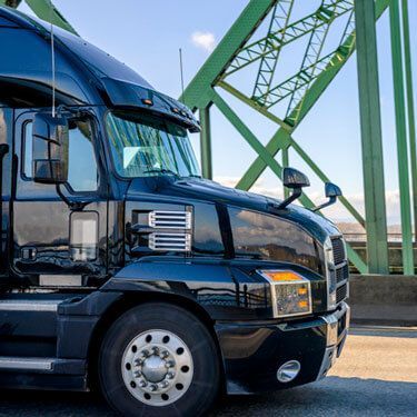 black semi-truck on bridge