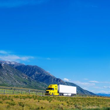 Freight Shipping from Utah to California - Yellow semi truck near mountains