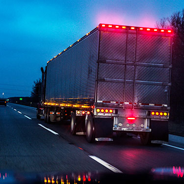 rear view of semi-truck lights on driving highway at night