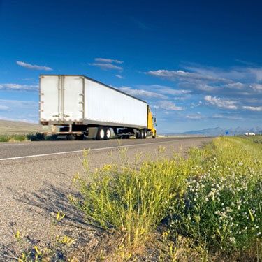 Freight Shipping from Oklahoma to Florida - Rear view of yellow truck on highway