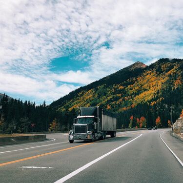 Freight Shipping from Virginia to California - Black semi truck by mountains