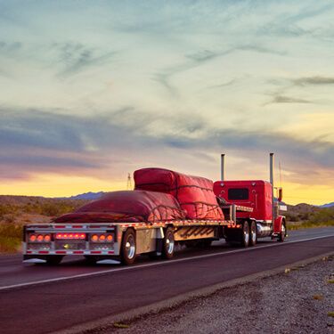 Shipping Freight from Maine to Texas - Red semi-flatbed truckload on highway