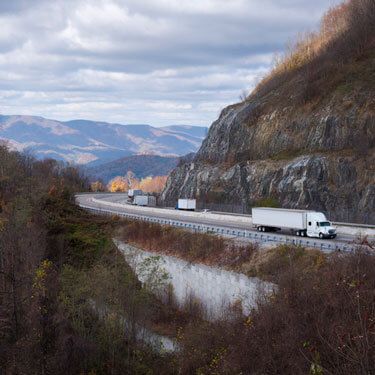 freight truck loads on mountainside highway