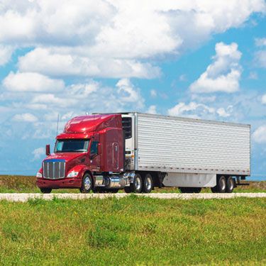 freight-shipping-from-maryland-to-florida - red freight truck driving on highway on nice day with clouds