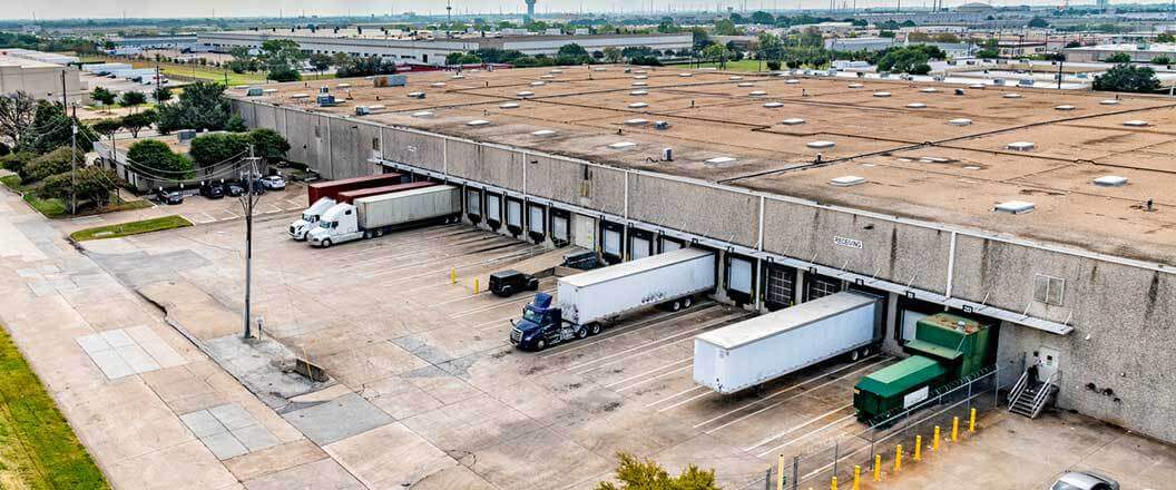 An aerial view of semi docked at a warehouse facility