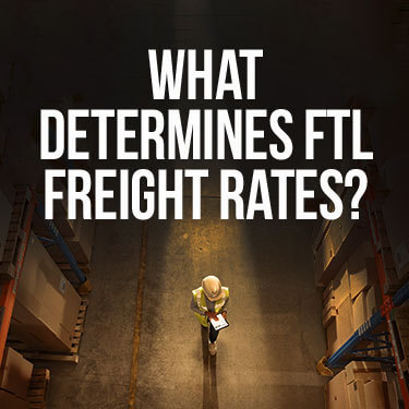 How is freight shipping calculated with an overhead view of a warehouse worker walking between an aisle of boxed items