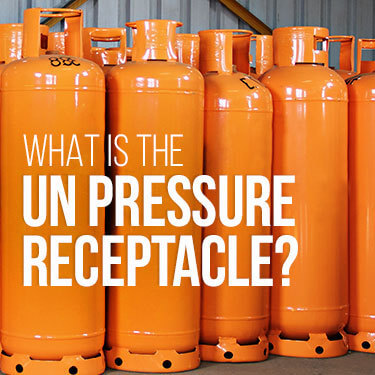 Orange compressed gas cylinders lined up next to each other within a warehouse