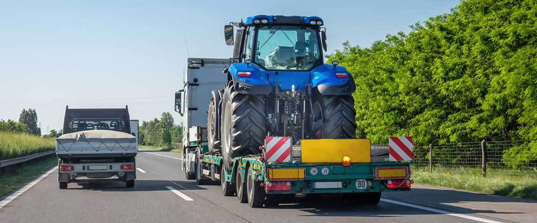 A semi hauling a tractor on a highway