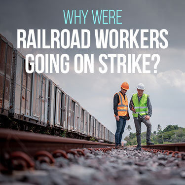 Railroad workers standing beside a train of box cars