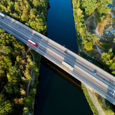 semi-trucks driving on bridge over river